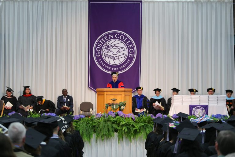 president addresses a crowd from a podium in front of the GC seal