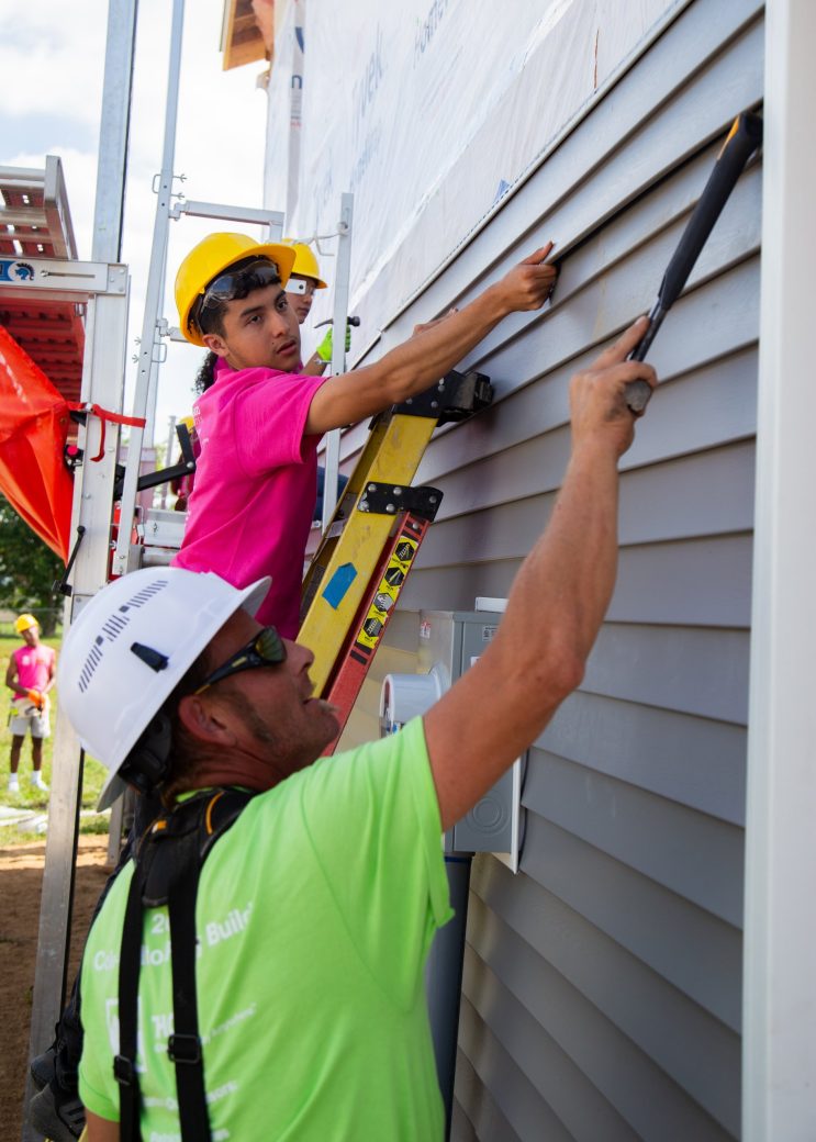 students doing community service building a house