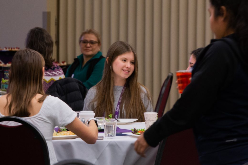 People eating at Woman doing a presentation at Celebrate Scholars