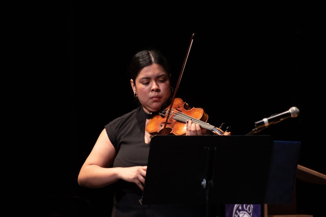 Woman playing violin on the stage at Celebrate Scholars Day 2024