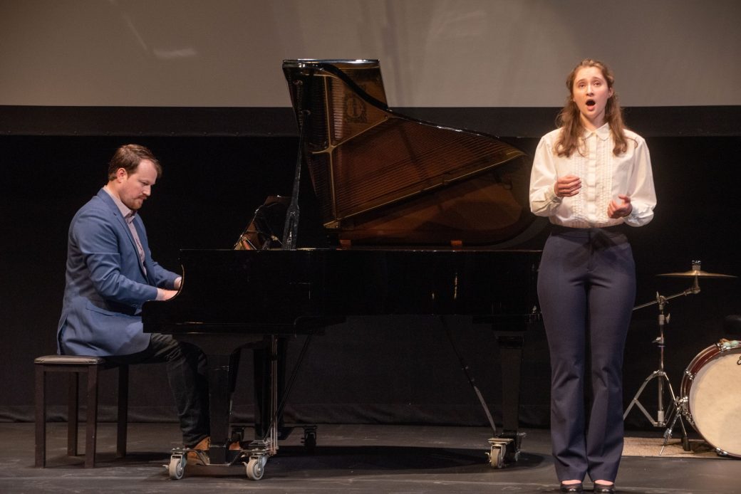 A man playing piano and a woman singing