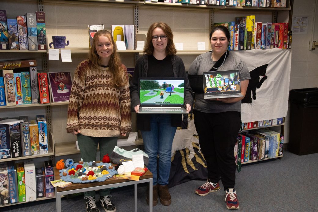 Two women crarryig two laptops