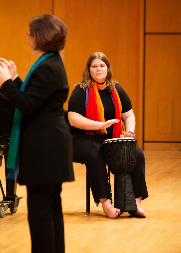 Woma seated on the stage