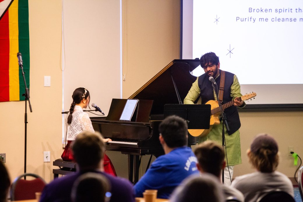 Woman playing piano and a man playing an acoustic guitar