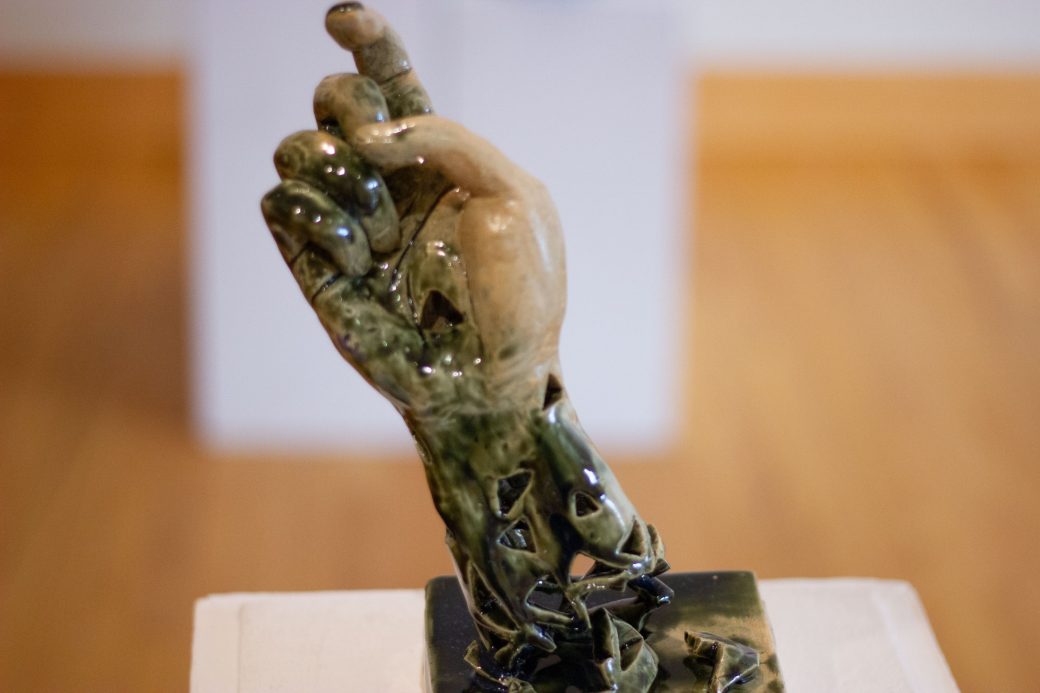 statue of a hand with the index finger pointing upwards