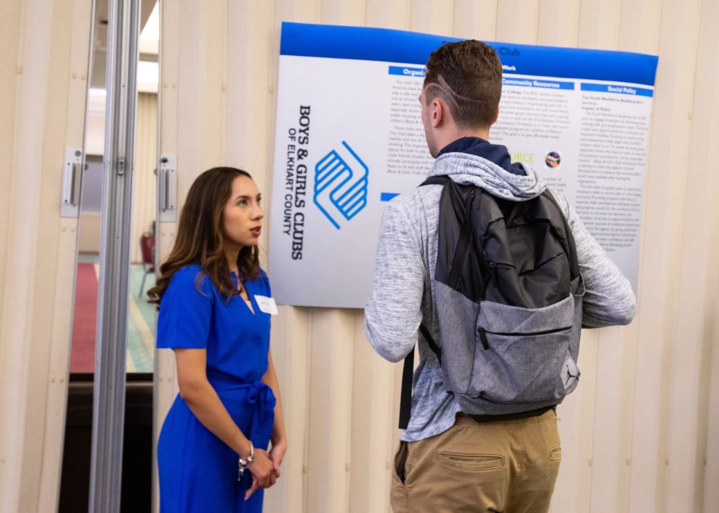 A man and a woman talking at Academic Symposium 2024
