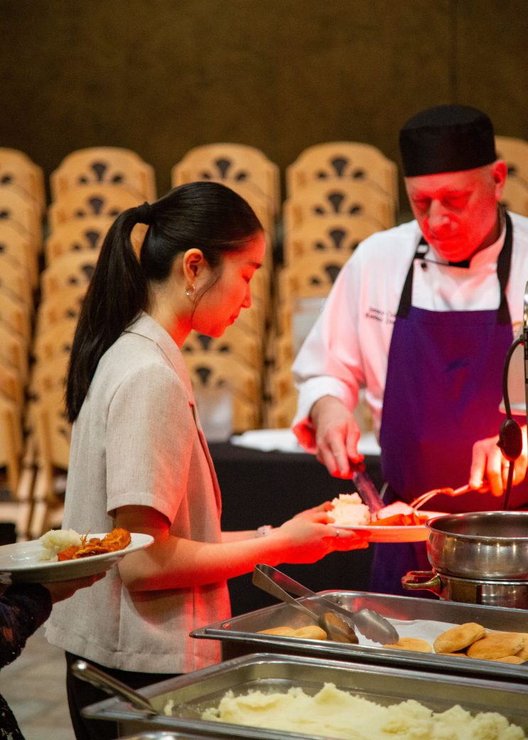 Woman serving themselve at President's Graduating Leaders Awards 2024