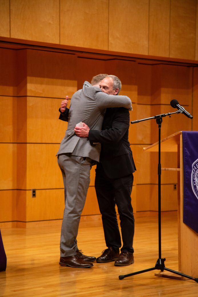 Two men hugging on the stage at President's Graduating Leaders Awards 2024