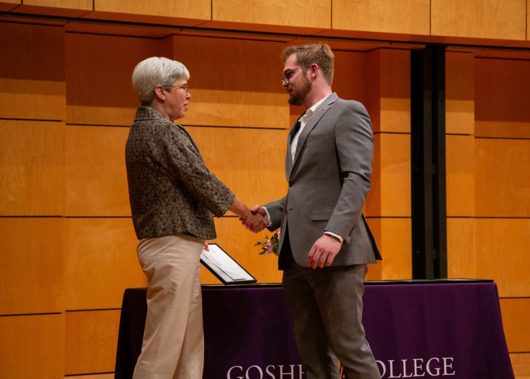 Two men on the stage handshaking at President's Graduating Leaders Awards 2024