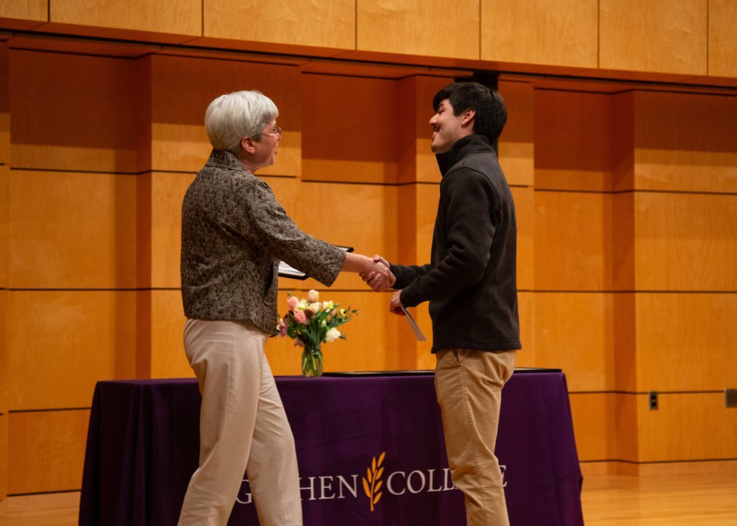 Two men on the stage handshaking at President's Graduating Leaders Awards 2024