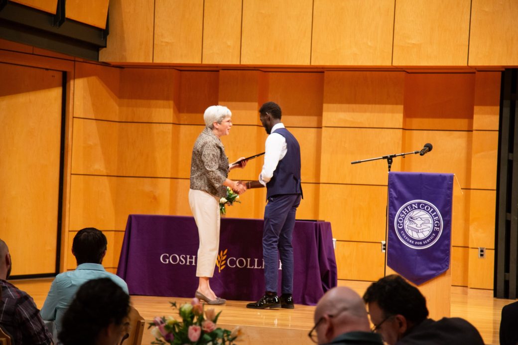 Two men doing a handshaking on the stage at President's Graduating Leaders Awards 2024