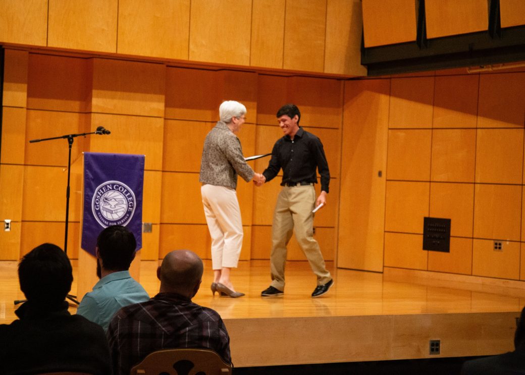 Two men doing a handshaking on the stage at President's Graduating Leaders Awards 2024