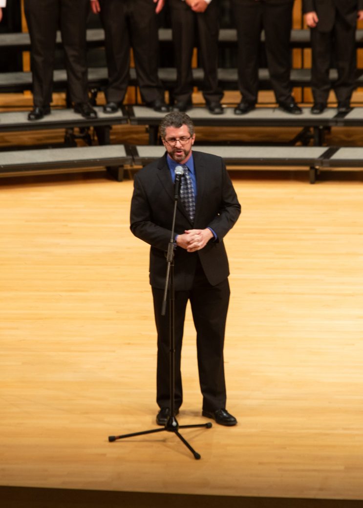 Man speaking on stage at low voice festival