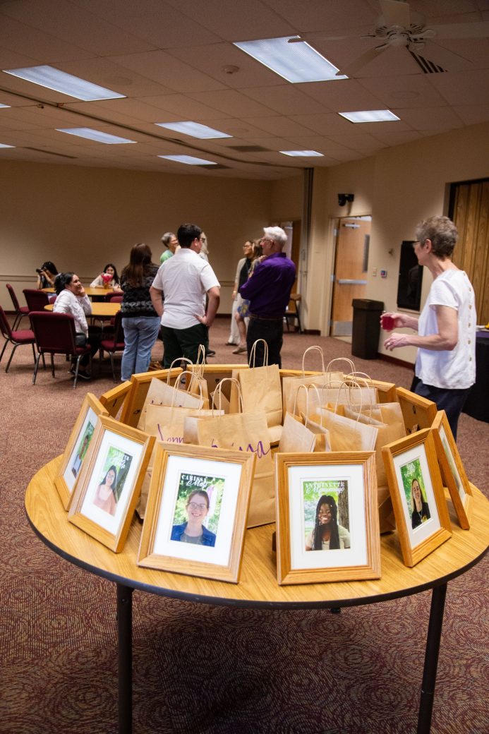 Table with photos of people in a frame at Academic Department Receptions and Baccalaureate Celebration
