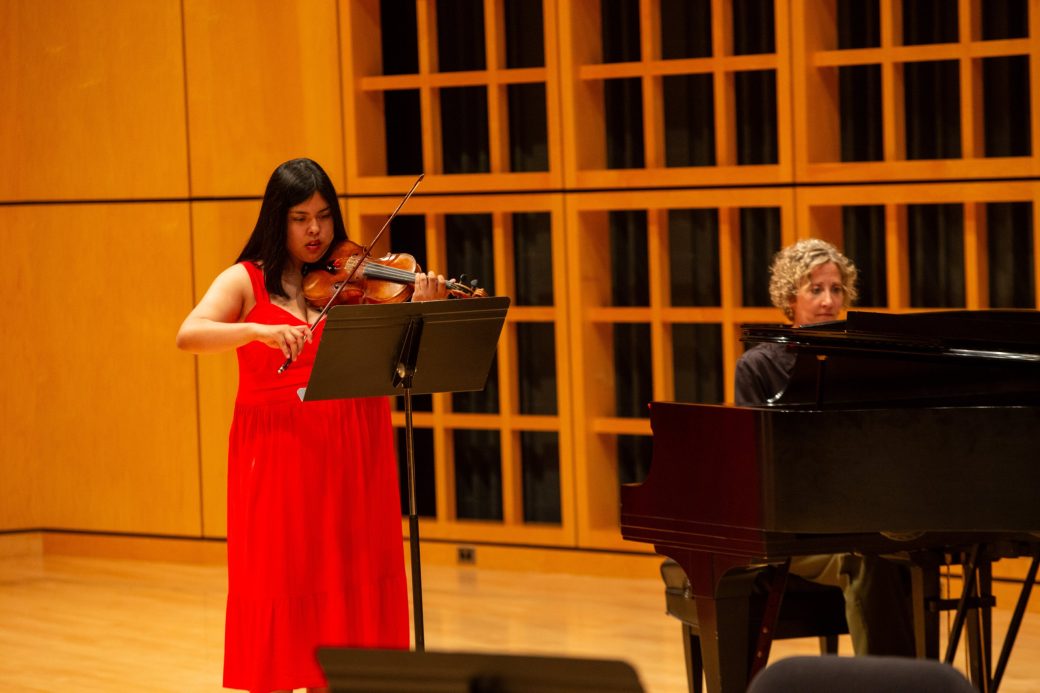 Woman singing and a man playing piano at Academic Department Receptions and Baccalaureate Celebration