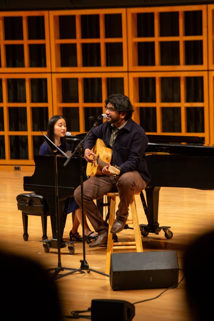Woman playing a piano and man playing acoustic guitar