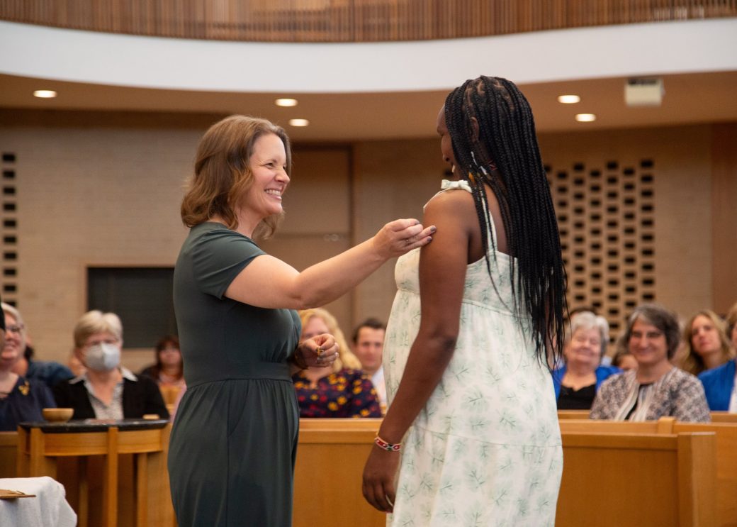 Woman putting a pin in a other woman at Commencement 2024: Nurses' Pinning Ceremony