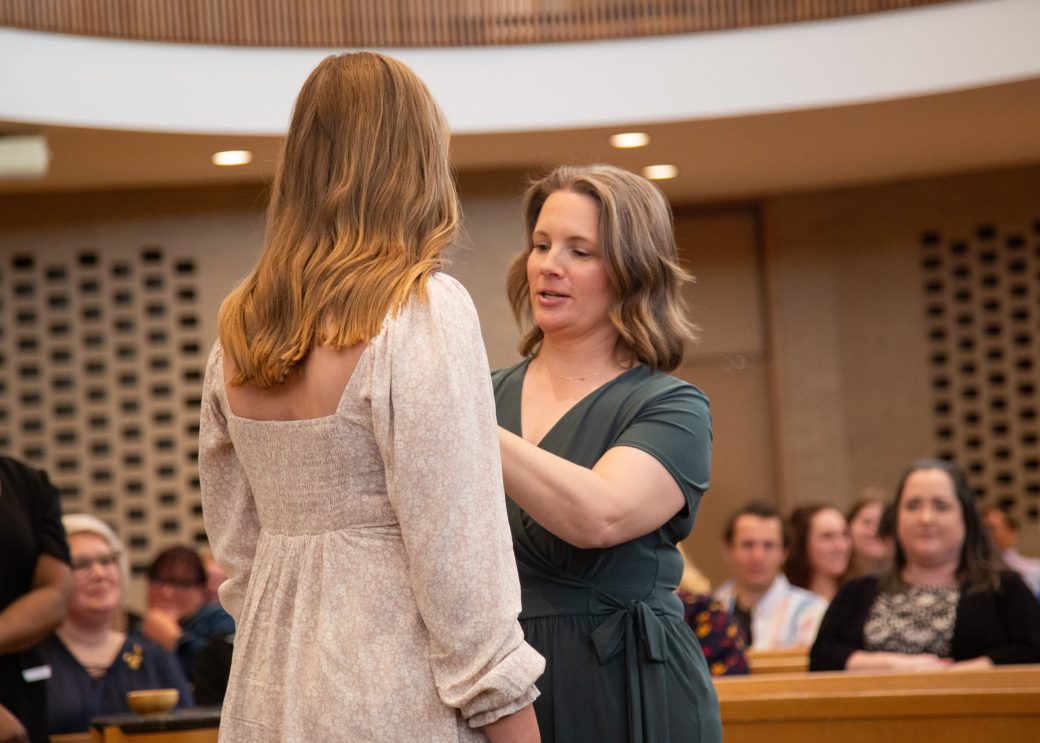 Woman putting a pin in a other woman at Commencement 2024: Nurses' Pinning Ceremony