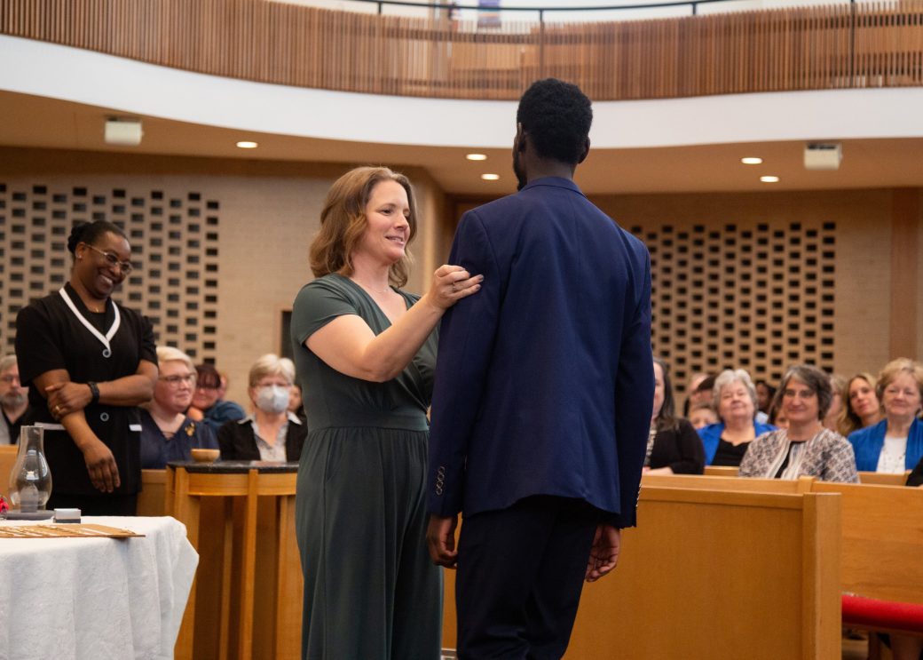 Woman putting a pin in a man at Commencement 2024: Nurses' Pinning Ceremony
