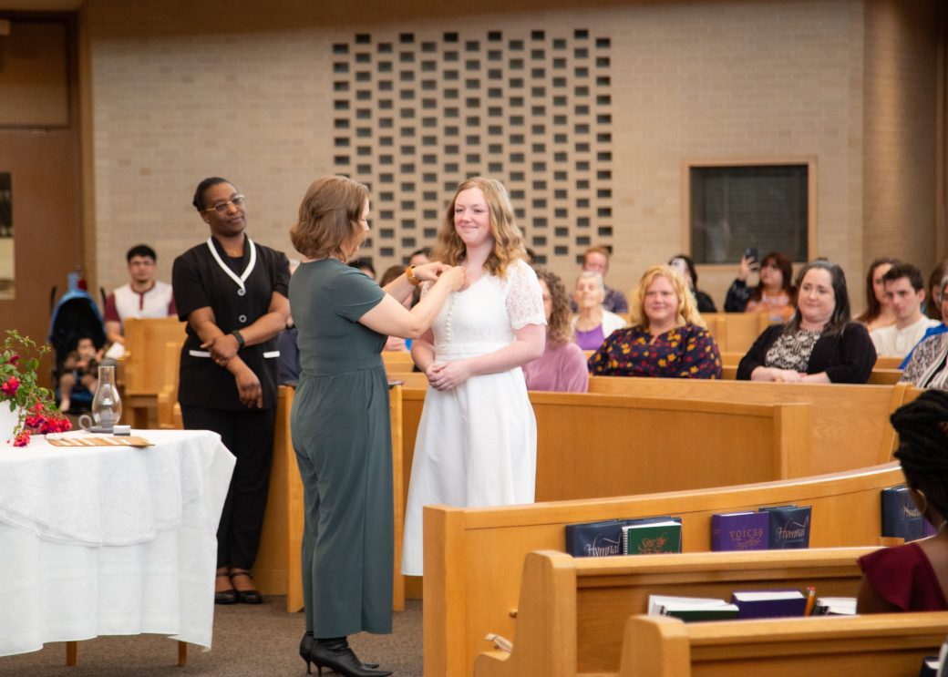 Woman putting a pin in a other woman at Commencement 2024: Nurses' Pinning Ceremony