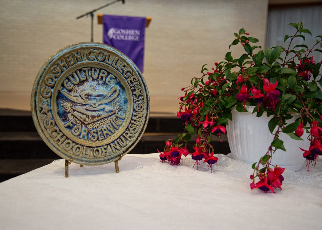 Table with flowers and a beatiful art at Commencement 2024: Nurses' Pinning Ceremony