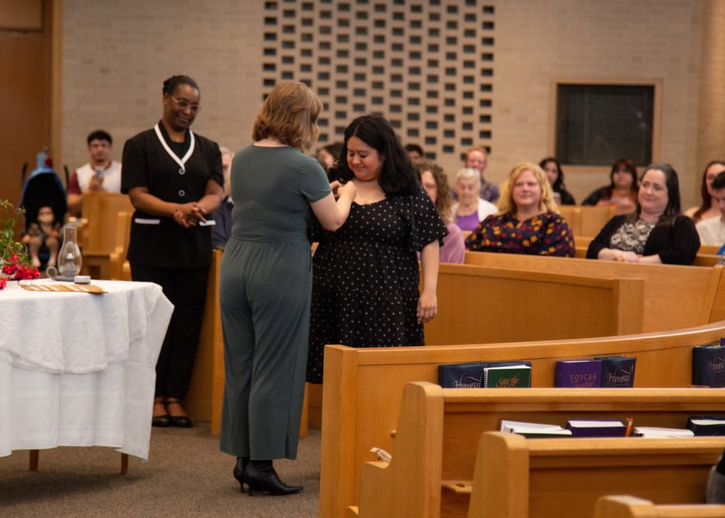 Woman putting a pin in a other woman at Commencement 2024: Nurses' Pinning Ceremony