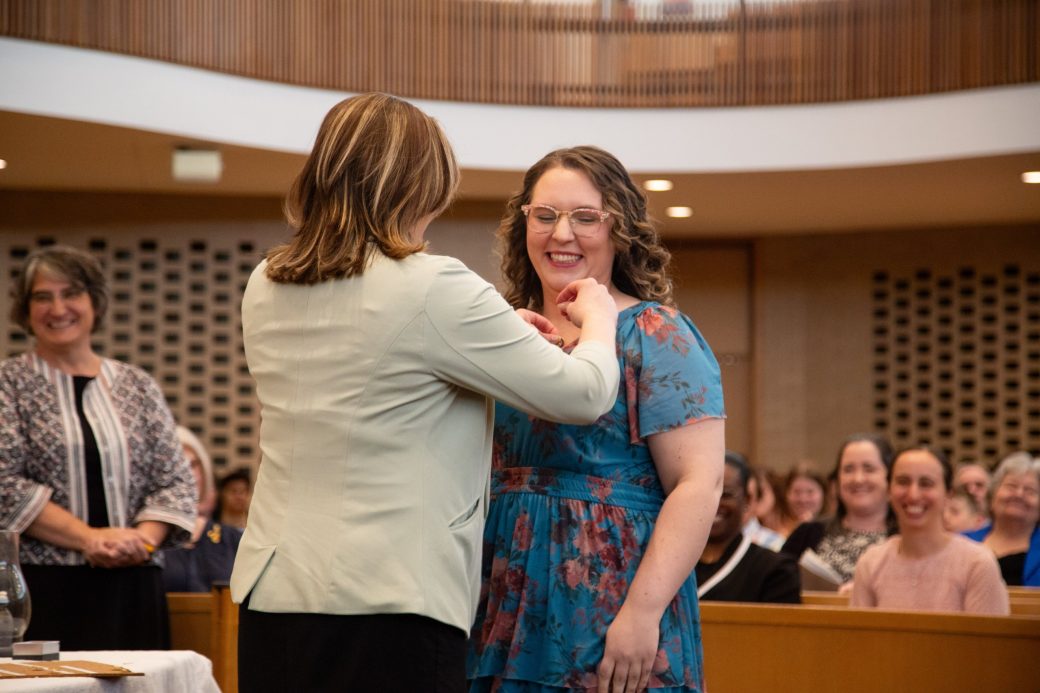 Woman putting a pin in a other woman at Commencement 2024: Nurses' Pinning Ceremony