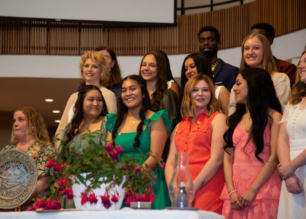 Pins nurses smiling to the camera at Commencement 2024: Nurses' Pinning Ceremony