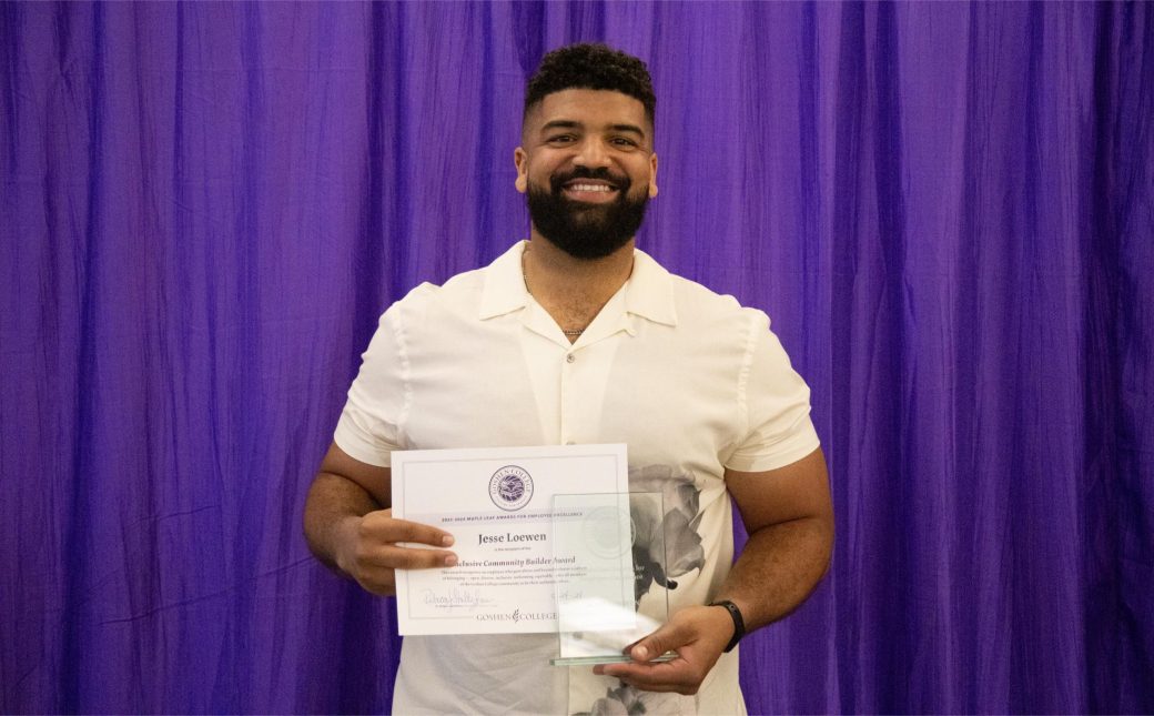 A man smiling at the camera with a certificate.
