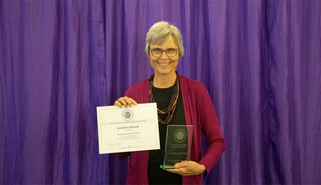 A woman smiling at the camera with a certificate.