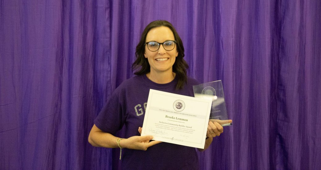 A woman smiling at the camera with a certificate.