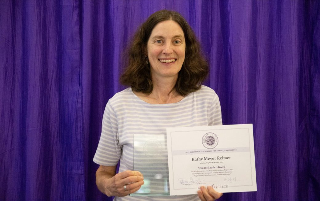 A woman smiling at the camera with a certificate.