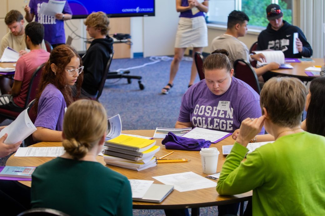 Goshen college students at the table with notebooks