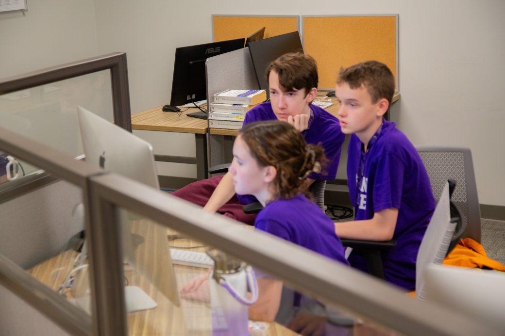 Teens talking and stirring in a computer