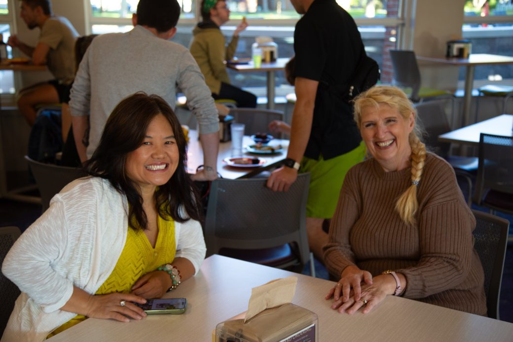 Two Goshen college students smiling to the camera at Westlawn Dining Hall