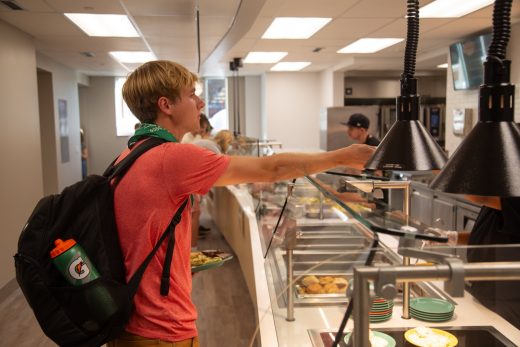 Student ordering food from the grill in the dining hall.