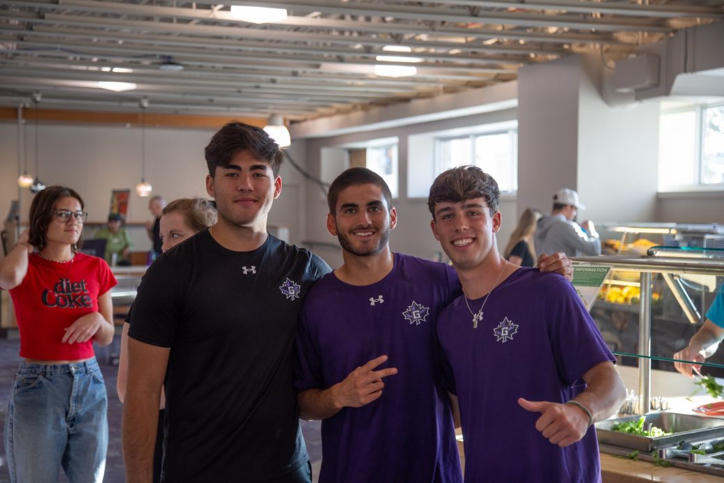 Three goshen college students hugging and stricking a pose
