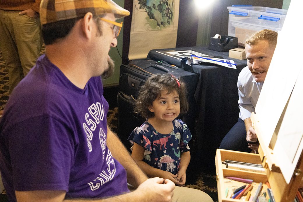 Kid talking with an artist
