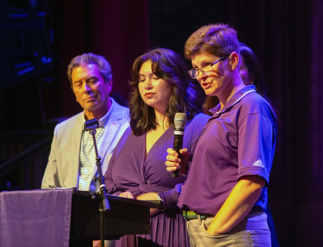 People giving a speeach at the stage's podium