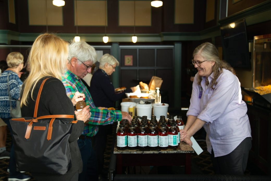 Woman looking at the products at the table at Goshen's college Marquee at Connectapalooza