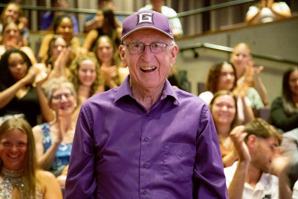 A man with Goshen's college clap and dressing a purpleformal attire