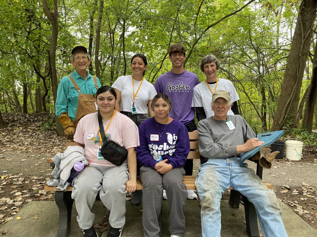 People smiling to the camera in a forest