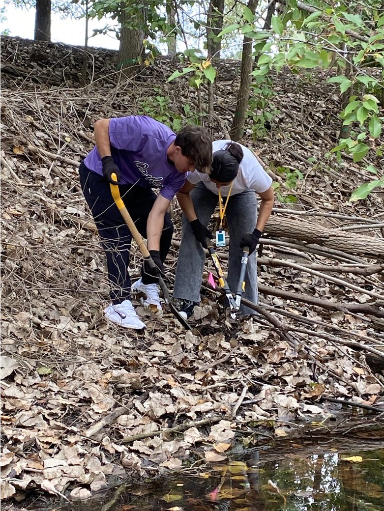 Two men of Goshen College planting a tree