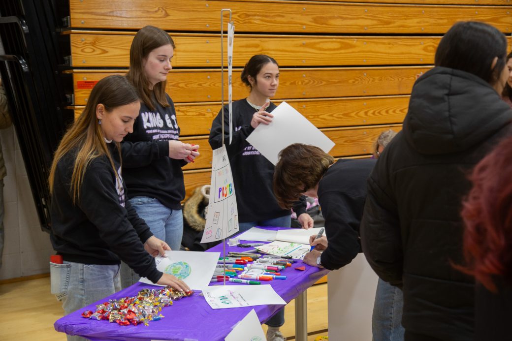 Goshen college students decorating the papers
