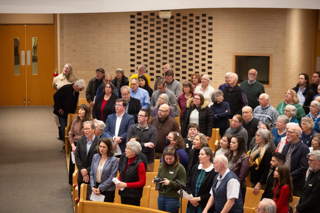 Public standing andpaying attention at Anabaptism Ceremony