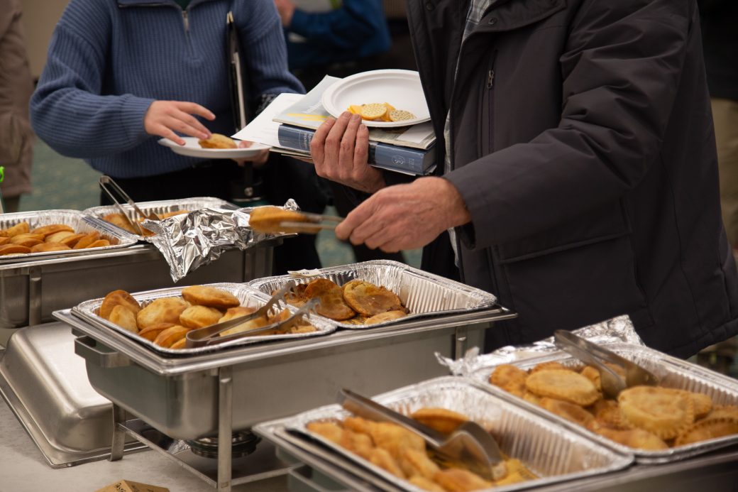 People serving themselves with foodof the table at Anabaptism Celebration