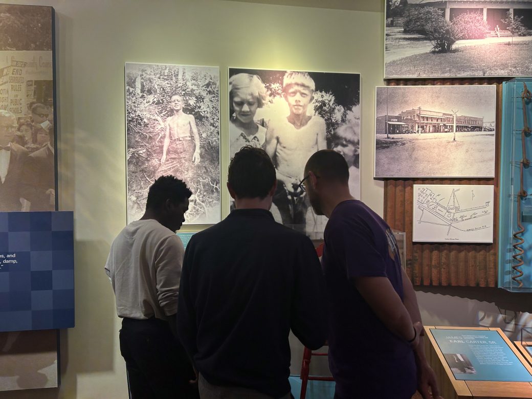 Three Goshen's students looking at photos of kids
