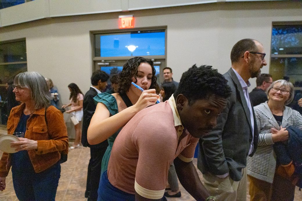 a woman signing the back of a man