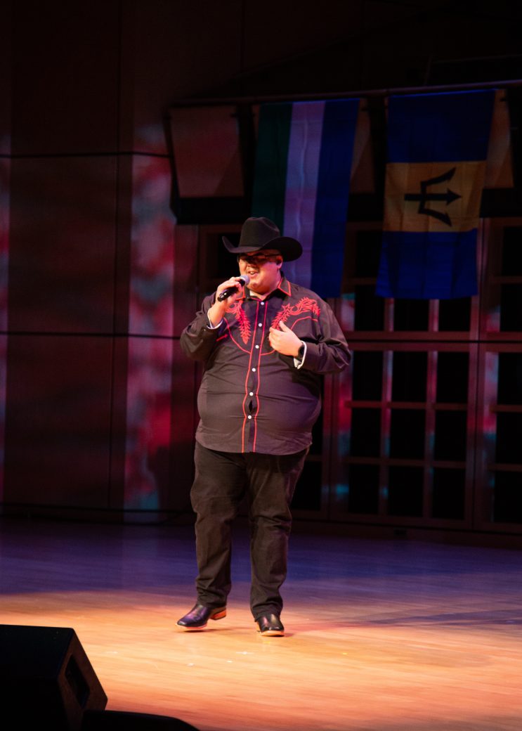 Man speaking in a stage at International Student Club Coffeehouse 2023