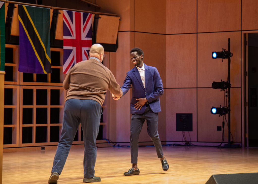 Two men handshaking on the stage at International Student Club Coffeehouse 2023